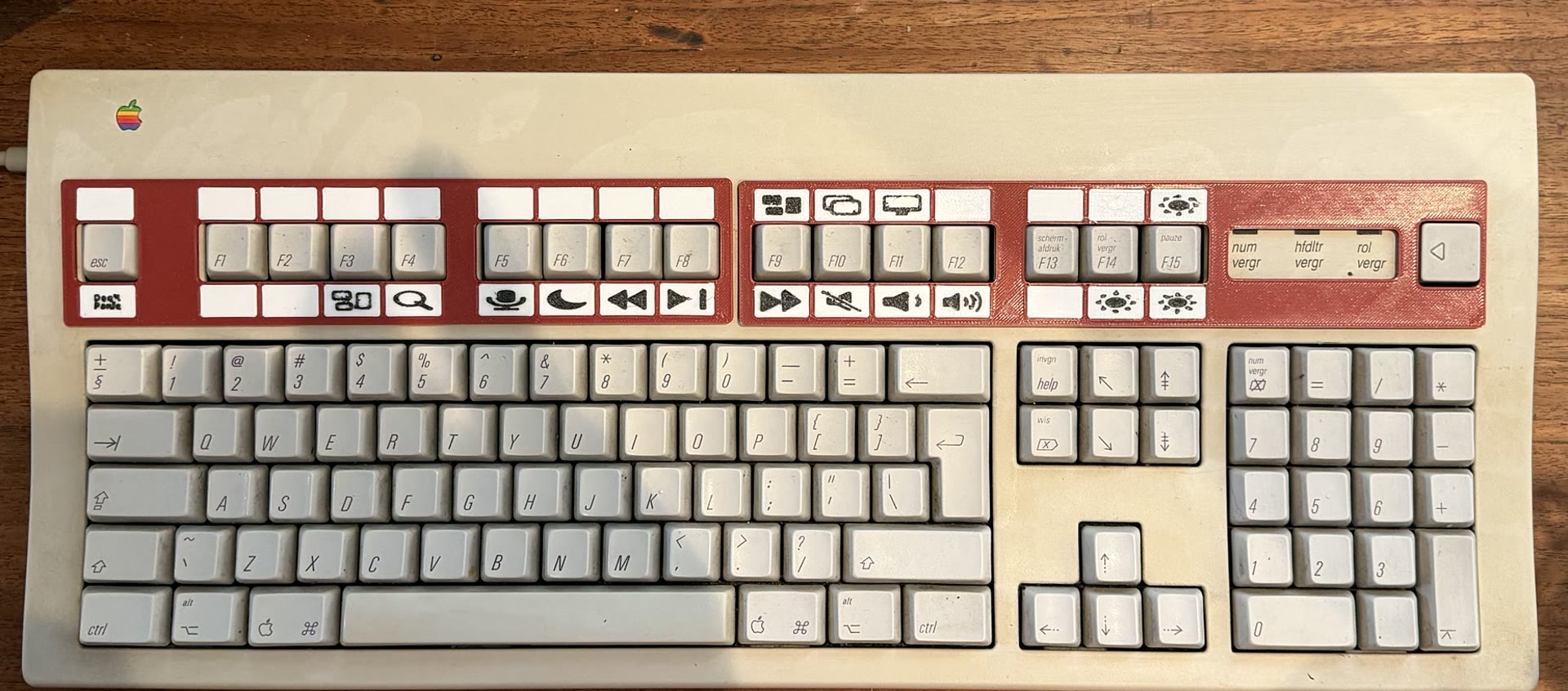 Updated real-world prototype: red left and right function-label frames installed on an Apple Extended Keyboard II, with white modular icon tiles, status lights, and a Layer key